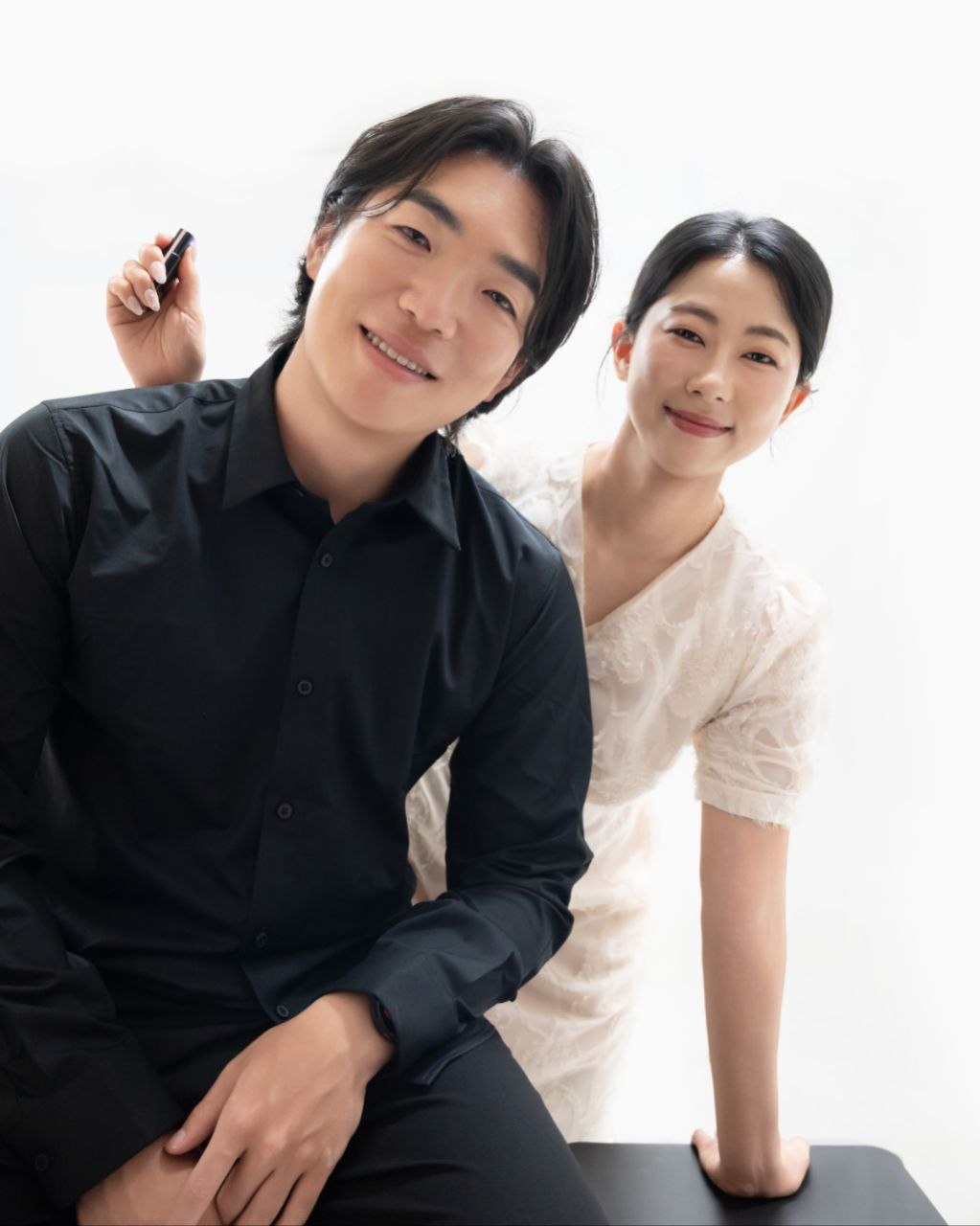 스튜디오에서 장난스럽게 기대 선 신랑 신부