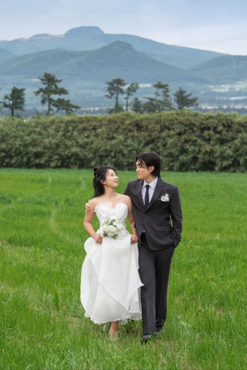 들판에서 함께 걷는 신랑 신부